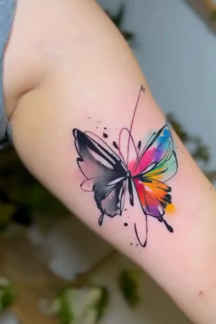 a colorful butterfly tattoo on the arm