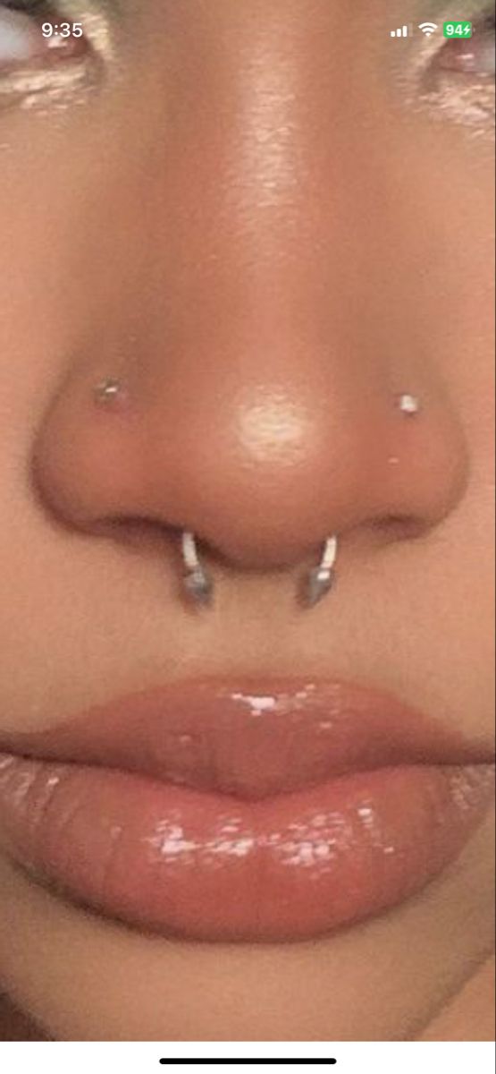 a woman's nose with piercings on it and the bottom part of her nose