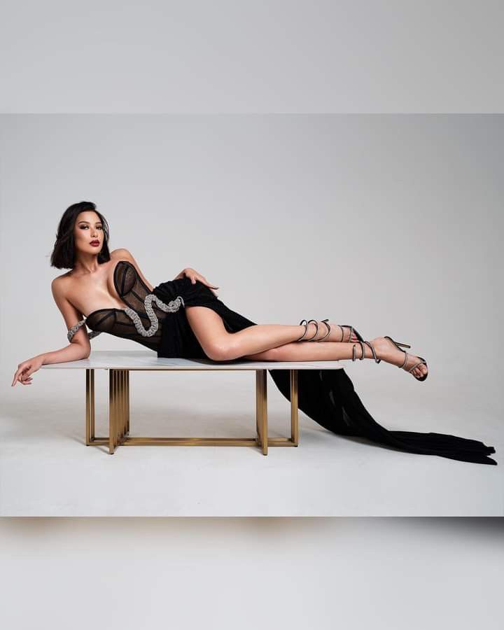 a woman laying on top of a white table next to a black and gold bench