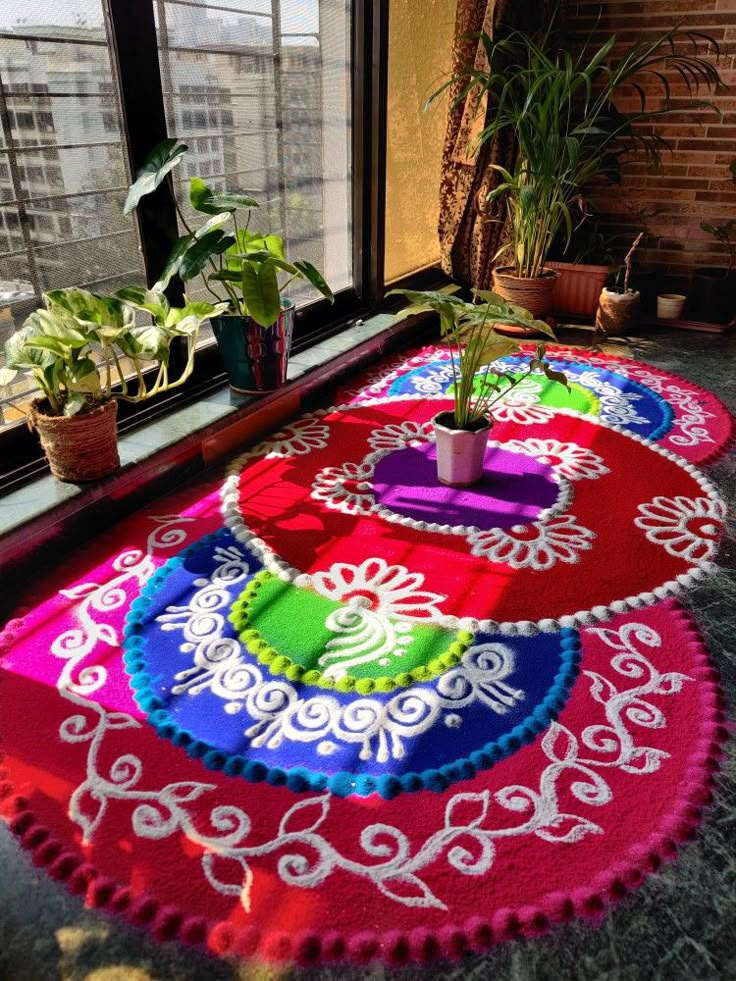 colorful rugs on the ground in front of a window with potted plants and windowsill