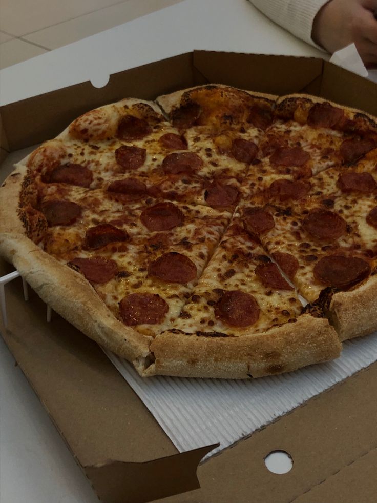 a large pepperoni pizza sitting in a box