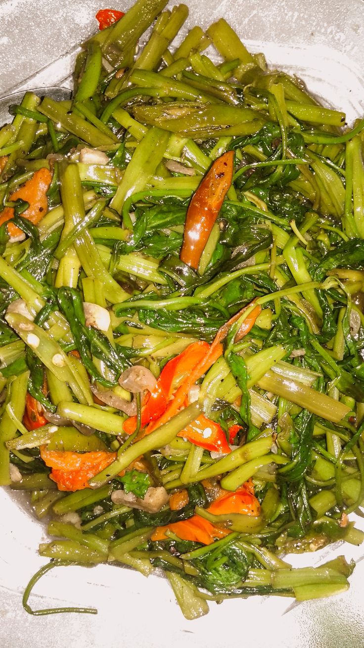 a white plate topped with green beans and carrots