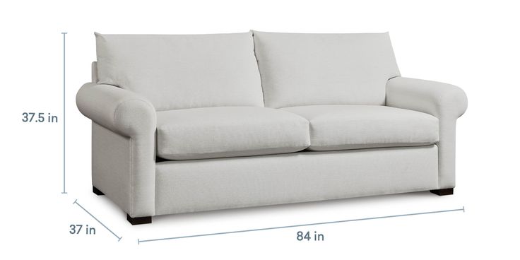 a white couch sitting on top of a wooden floor next to a tall ruler line