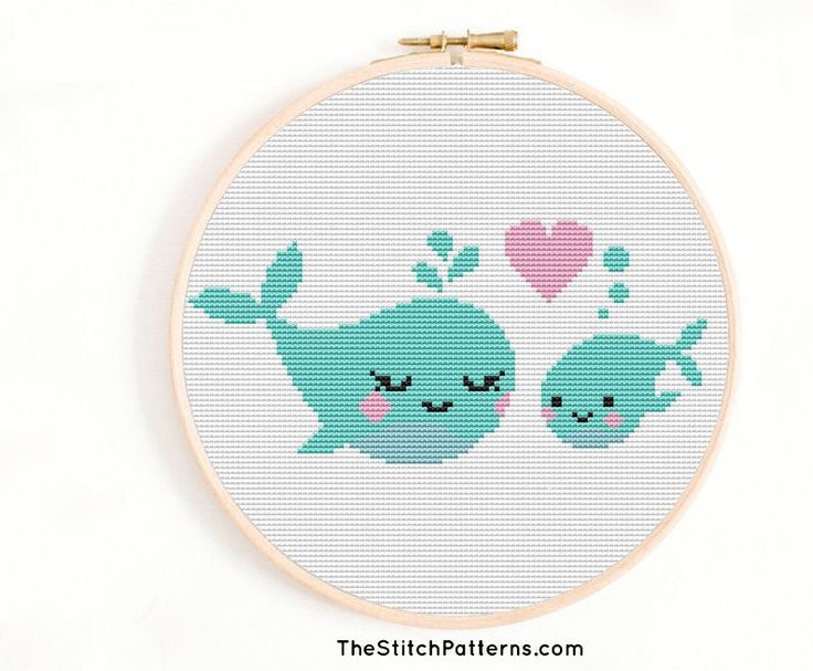 the cross stitch pattern shows two blue whales with hearts on their backs, and one is holding