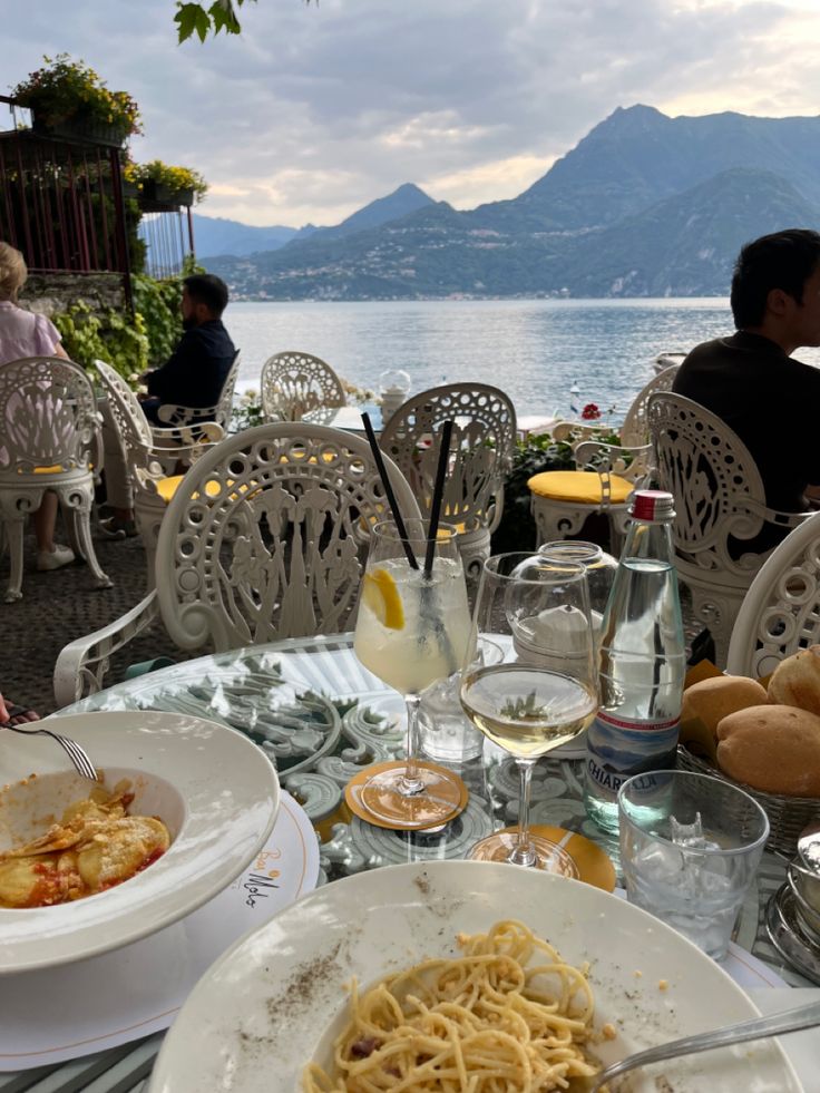 an outdoor dining area with plates of food and water