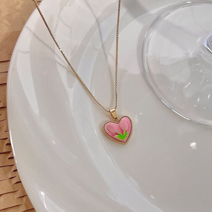 Trendy Pink tulip flower heart shaped pendant charm necklace, 14K real gold plated chain. Crafted from high-quality materials, this stunning necklace features a delicate heart-shaped pendant adorned with a beautiful pink tulip motif, symbolizing love, beauty, and new beginnings. Cute girly aesthetic, y2k layering necklace choker. Exquisite statement necklace to elevate your fashion style. 💎 Features: ♥ Handmade jewelry ♥ Finish Tone: Finest 14K gold plated | Pink ♥ Approximate Measurements: - L Tulip Necklace Aesthetic, Pink Clavicle Chain Necklace For Valentine's Day, Cute Flower Jewelry For Valentine's Day, Trendy Rose Gold Heart Necklace, Pink Flower Charm Necklace With Flower Pendant, Pink Pendant Charm Necklace With Delicate Chain, Feminine Clavicle Chain Necklace For Valentine's Day, Pink Heart Pendant Charm Necklace For Mother's Day, Pink Heart Charm Necklace With Heart Pendant