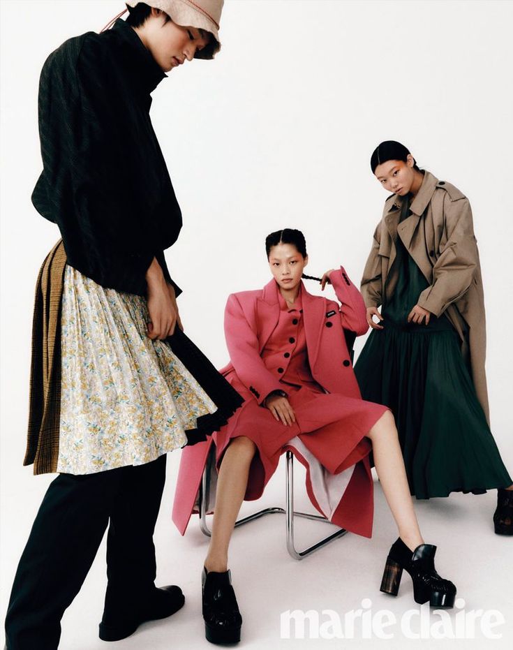 three women in coats and dresses sitting on chairs