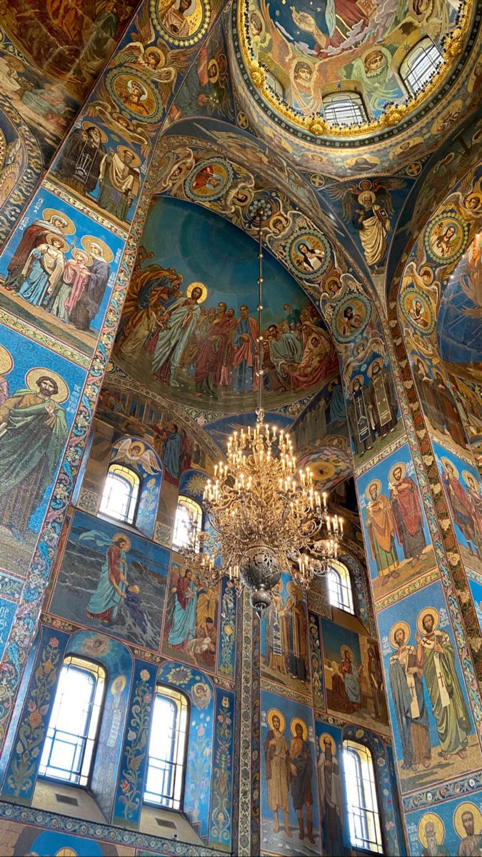 the interior of an ornately painted church with chandelier