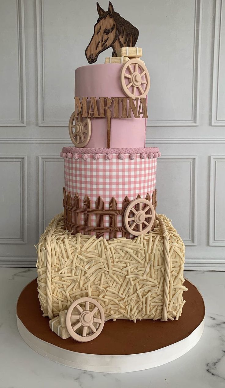 a three tiered cake with a horse and carriage on the top is made out of straw