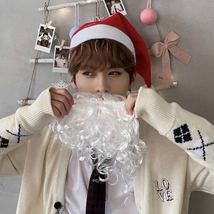 a young man wearing a santa hat and beard