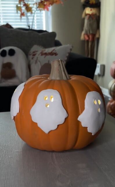 a pumpkin decorated with ghost eyes on a table