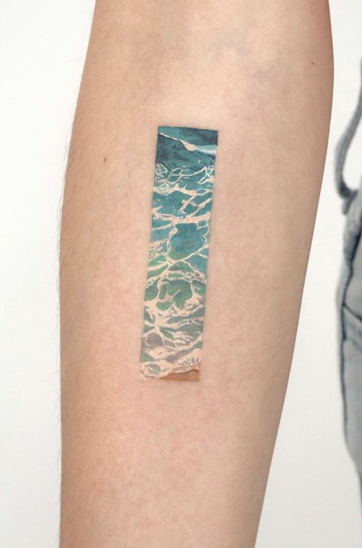 a piece of paper that has been placed on someone's arm with the ocean in it