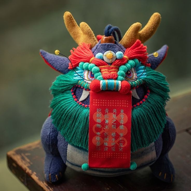 a small stuffed animal with horns on it's head and a red ribbon around its neck