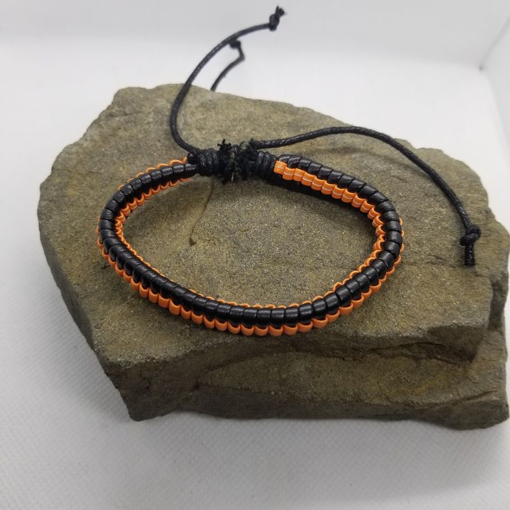 If you like orange and black, then this simple bracelet is perfect for you to add to your collection. The bracelet is adjustable via a sliding knot. Product Information Material: PU leather Clasp Type: rope (sliding knot) Adjustable: 6.5 inches to 8 inches Casual Orange Braided Bracelets For Friendship, Casual Orange Braided Bracelet For Friendship, Handmade Orange Casual Friendship Bracelet, Casual Handmade Orange Friendship Bracelets, Casual Handmade Orange Friendship Bracelet, Adjustable Orange Beaded Bracelets For Everyday, Black Leather Bracelet With Adjustable Band, Adjustable Wrap Bracelet With Sliding Knot, Casual Jewelry With Adjustable Band For Friendship