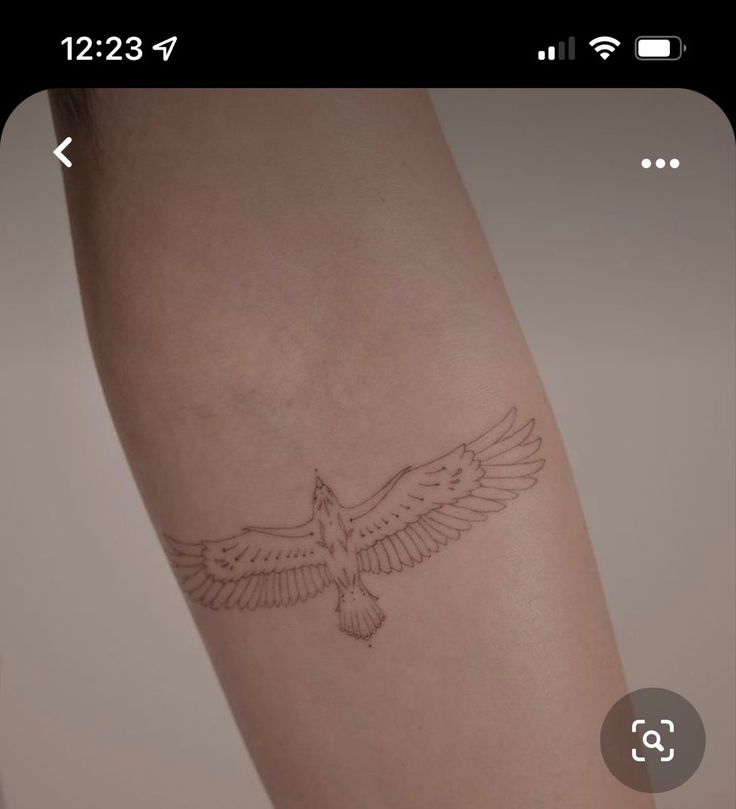 a small bird tattoo on the arm