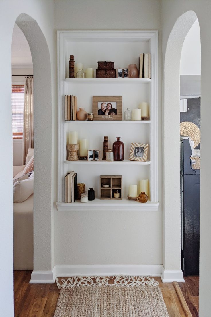 a living room filled with lots of white shelves