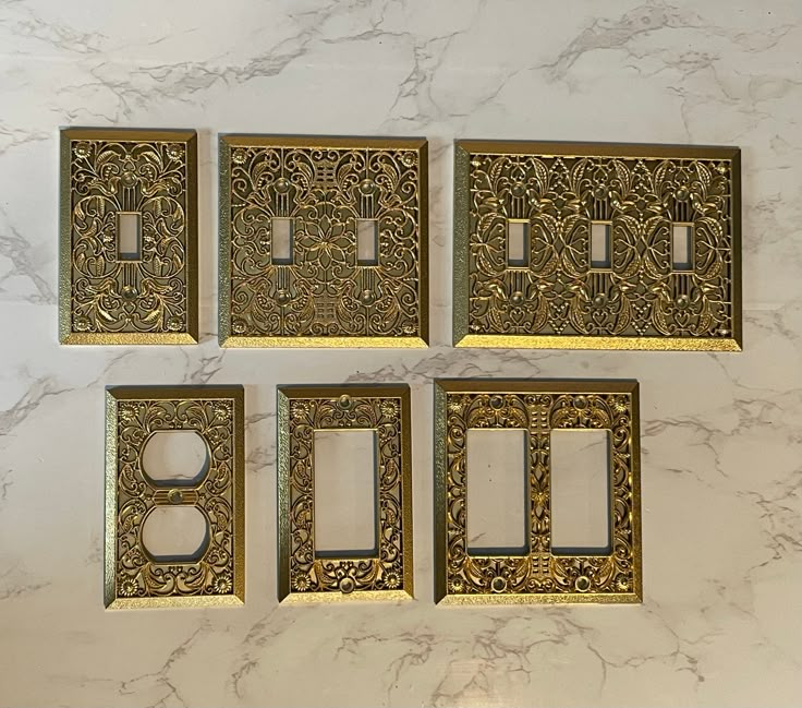 four decorative switch plates on a marble wall