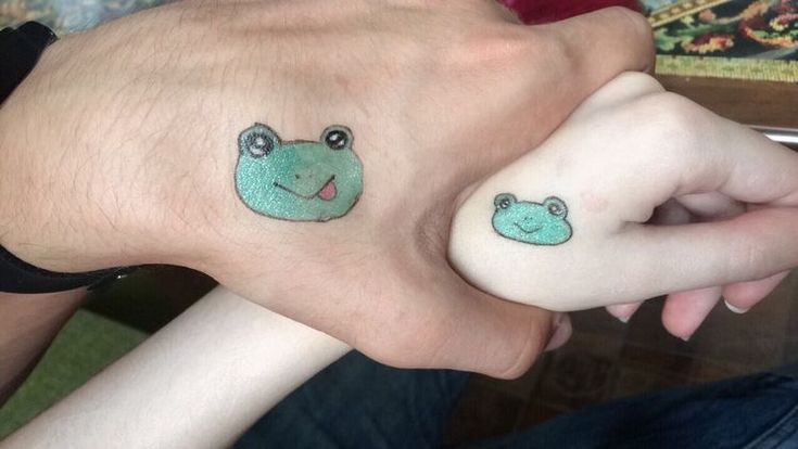 two people with matching tattoos on their hands