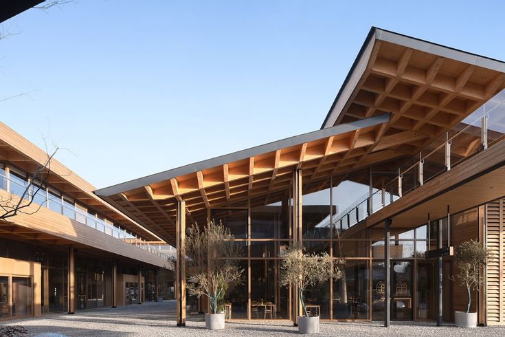 the outside of a building with large windows and wooden beams on it's sides