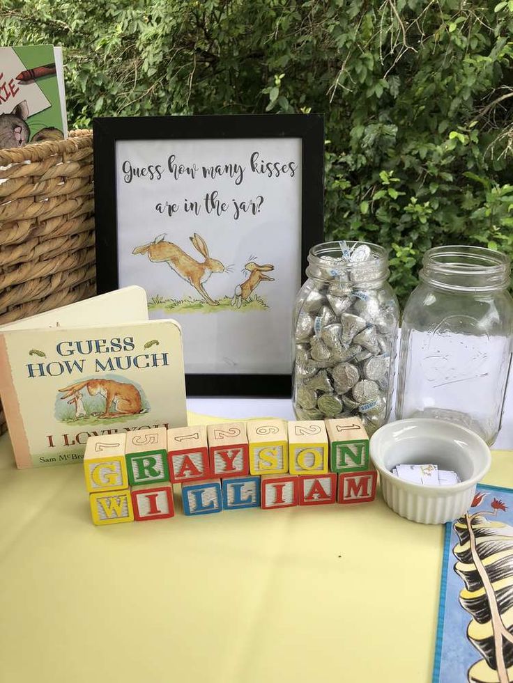 some books are sitting on a table next to a glass jar with rocks in it