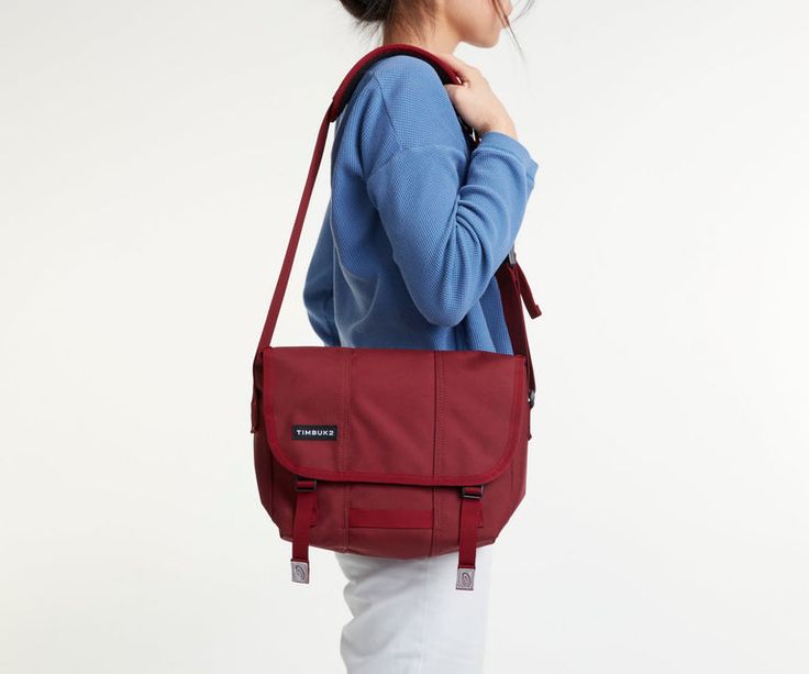 a woman carrying a red bag on her shoulder