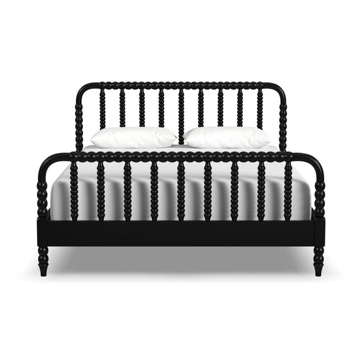 a black bed frame with white pillows on top of it and two side tables next to it