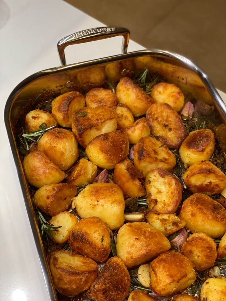 a casserole dish filled with potatoes and herbs