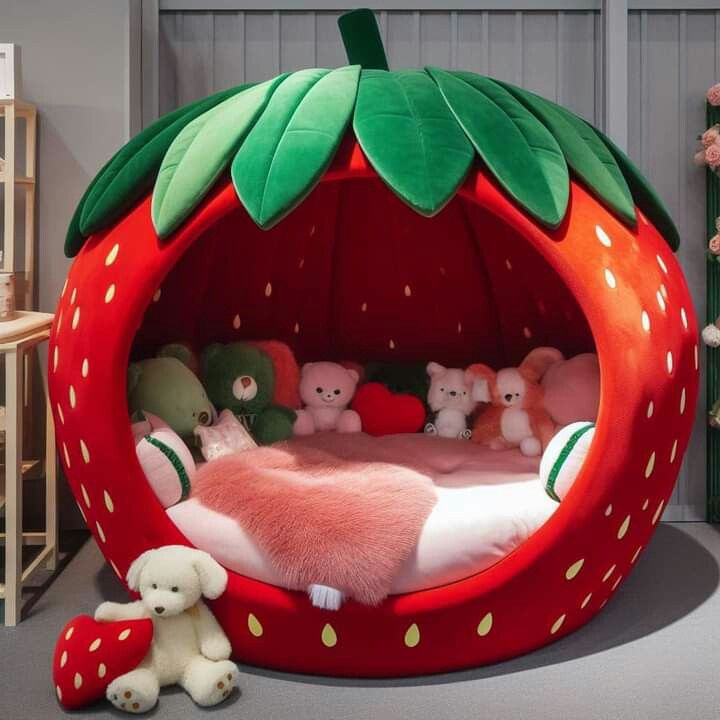 a strawberry shaped bed with stuffed animals in it