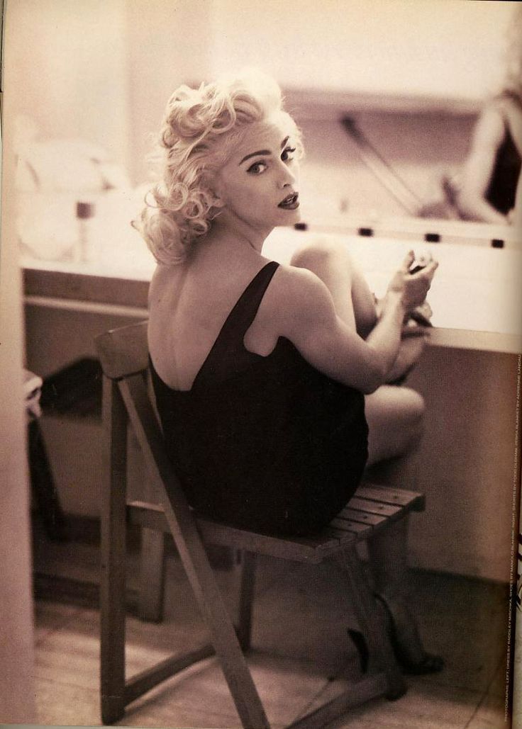 a black and white photo of a woman sitting on a chair