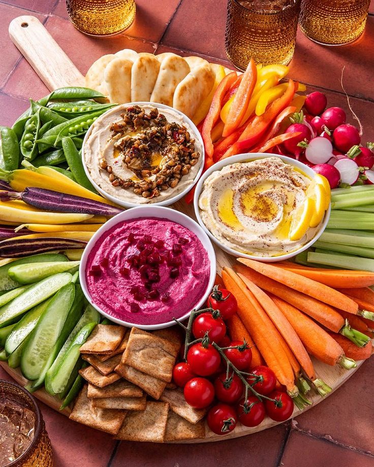 a platter filled with dips and vegetables