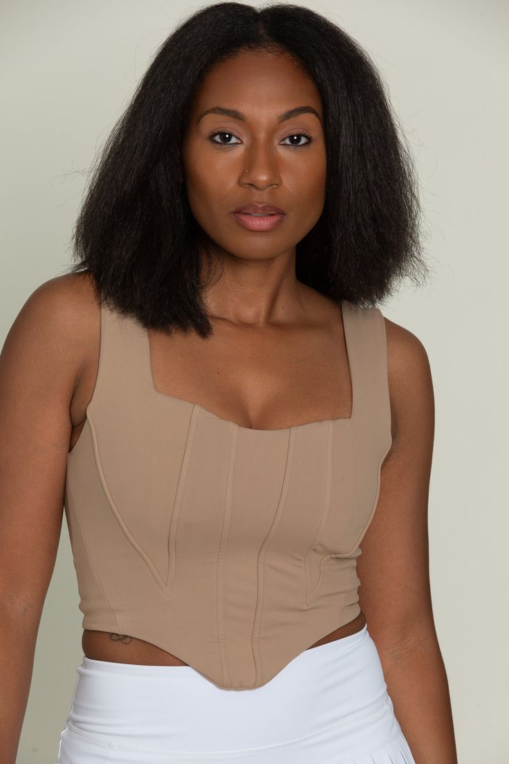 Our Brown Beige Corset Tank Top is so stunning and versatile. This corset-style tank has wide straps, a curved hem, and structured paneling on the bodice. Made for everyday, this tank is double lined for maximum support. Chic Crop Top With Built-in Bra And Wide Straps, Sleeveless Corset With Built-in Bra And Fitted Bodice, Chic Sleeveless Corset With Removable Pads, Chic Fitted Tank Top With Wide Straps, Chic Sleeveless Corset With Removable Bra Pads, Chic Fitted Tank Top With Boned Bodice, Elegant Fitted Tank Top With Wide Straps, Chic Sleeveless Camisole With Corset Back, Chic Tank Top With Corset Back