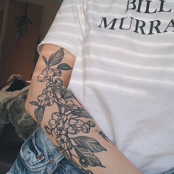 a man with a flower tattoo on his arm