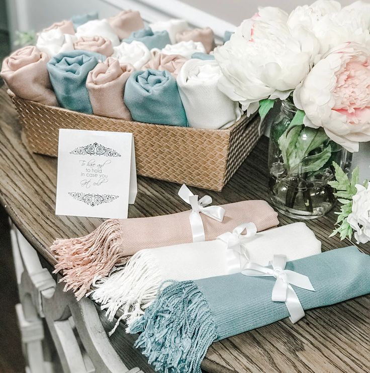 the table is set with towels, flowers and cards for guests to write on them