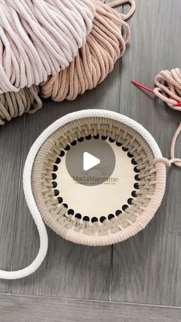 the yarn is being used to make a basket on the floor with it's handles