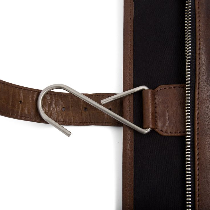 an open brown leather wallet with a metal hook on the side and two zippers attached to it