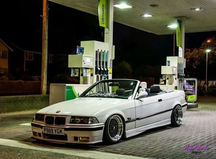 a white car parked in front of a gas station