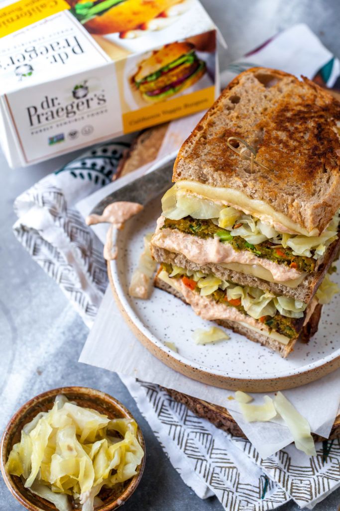 a sandwich cut in half sitting on top of a plate next to a bowl of pasta