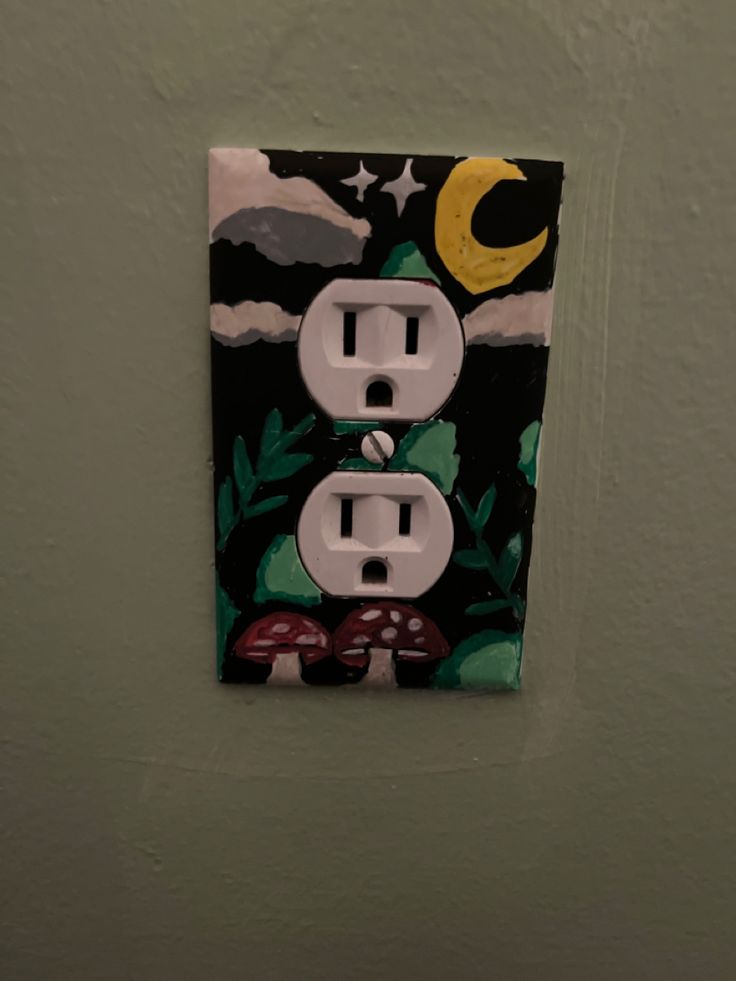 a light switch cover with an image of mushrooms and the moon above it on a green wall