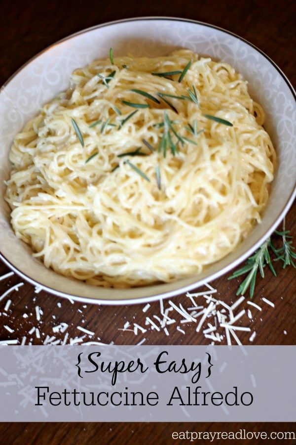 a white bowl filled with pasta and topped with sprig of parmesan cheese