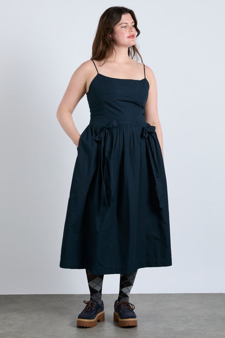 The Penelope apron dress is our navy midi dress featuring a corset style bodice with waist seam details and bows that gather into a fuller skirt. •100% Organic Cotton •Midi dress length •Adjustable straps •Shirred back panel •Select your normal size •Hidden zip detail •Made In India MODEL INFO: Model 1 is 5'9 and is wearing a UK 16. Model 2 is 5'10 and is wearing a UK 10. Crochet Stripe Scarf, Aw 2024, York Outfits, Damson Madder, Wishlist 2024, Wedding 2025, Checked Scarf, Detroit Wedding, Clean Body