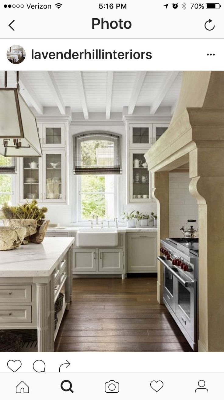 a large kitchen with white cabinets and wood floors