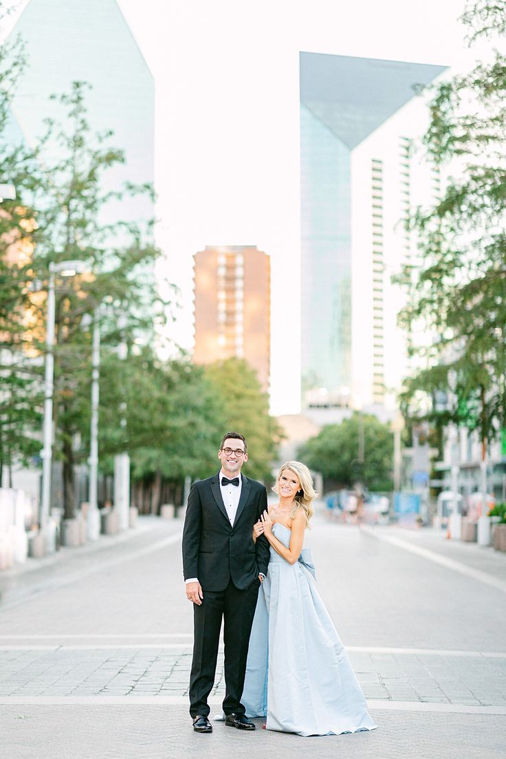 a man in a tuxedo and a woman in a blue dress pose for a photo