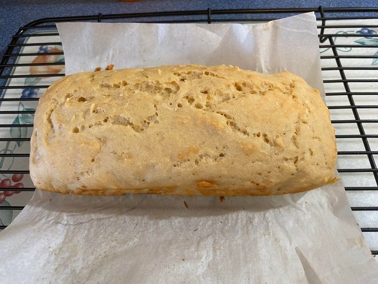 a loaf of bread sitting on top of a wire rack next to a paper towel