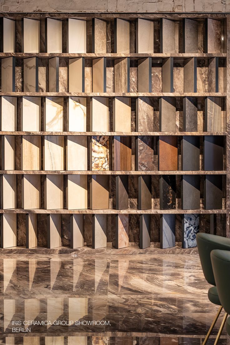 an empty room with chairs and shelves filled with wooden blocks on the wall, in front of a marble floor