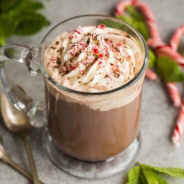 a cup of hot chocolate with whipped cream and candy canes