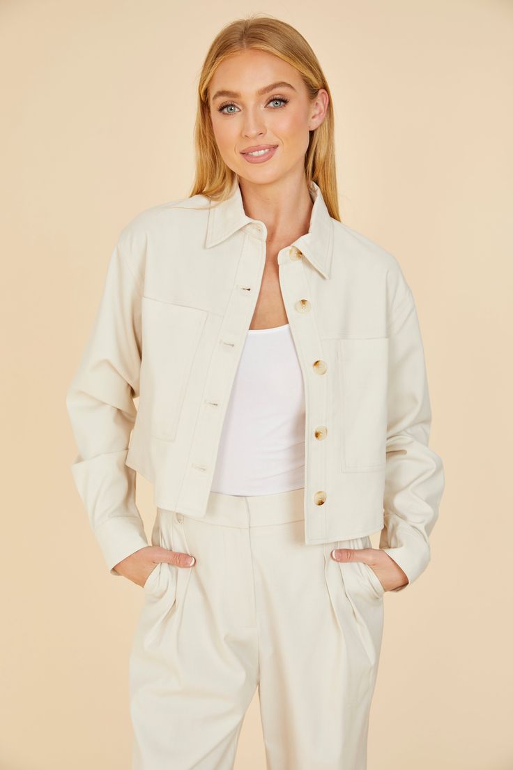 Stay on-trend as you transition to a springtime vibe with our Cream Cropped Jacket. This chic piece, featuring a trendy cropped design and two large front pockets, is a must-have for your spring wardrobe. The neutral cream color makes it the perfect complement to your airy and vibrant spring outfits. Whether paired with jeans or a sundress, this cropped jacket is a great choice for a breezy spring look. Cropped Front pockets Match with Full Leg Trouser style 75406 Dry clean Item # 75405 Chic Collared Utility Jacket With Flap Pockets, Beige Cropped Outerwear With Pockets, Cropped Beige Outerwear With Pockets, Chic Beige Utility Jacket With Flap Pockets, Chic Button-up Utility Jacket With Flap Pockets, Spring Utility Jacket With Flap Pockets For Work, Spring Utility Jacket With Lapel Collar And Flap Pockets, Chic Beige Cropped Jacket With Lapel Collar, Chic Cropped Beige Jacket With Pockets