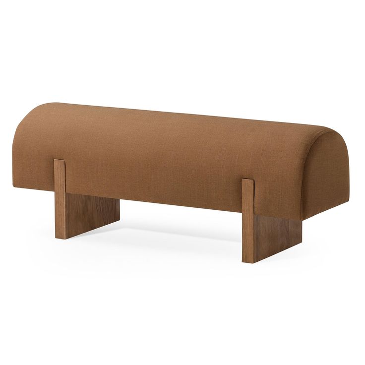 an upholstered bench with two wooden legs and a brown fabric cover on it