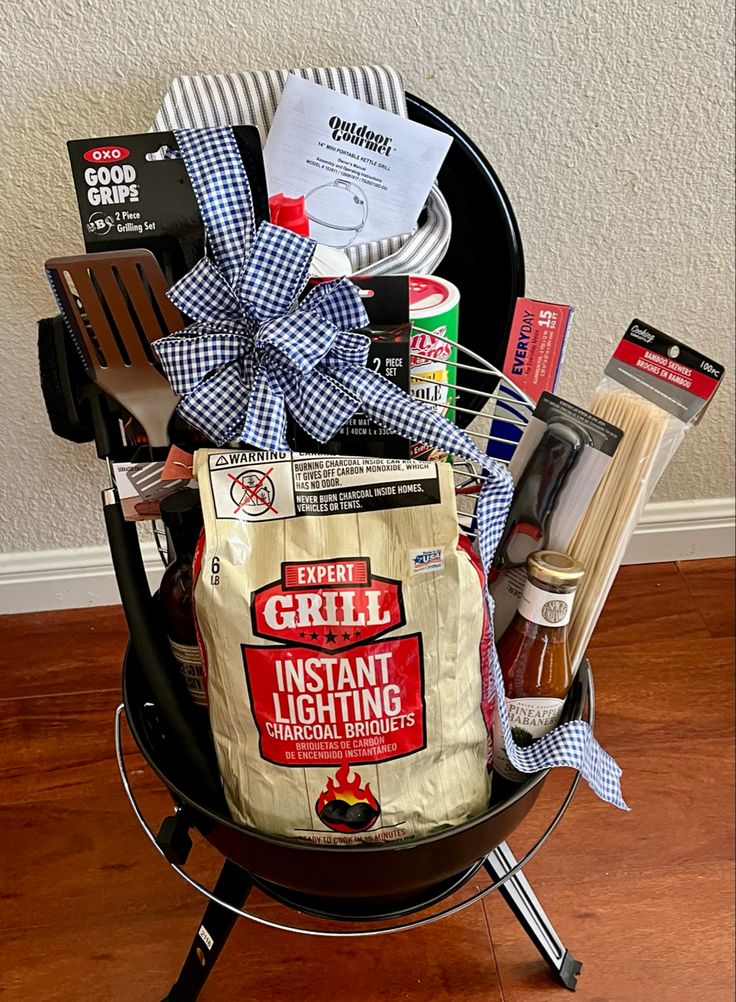 a grilling basket filled with food and cooking utensils sitting on top of a wooden floor