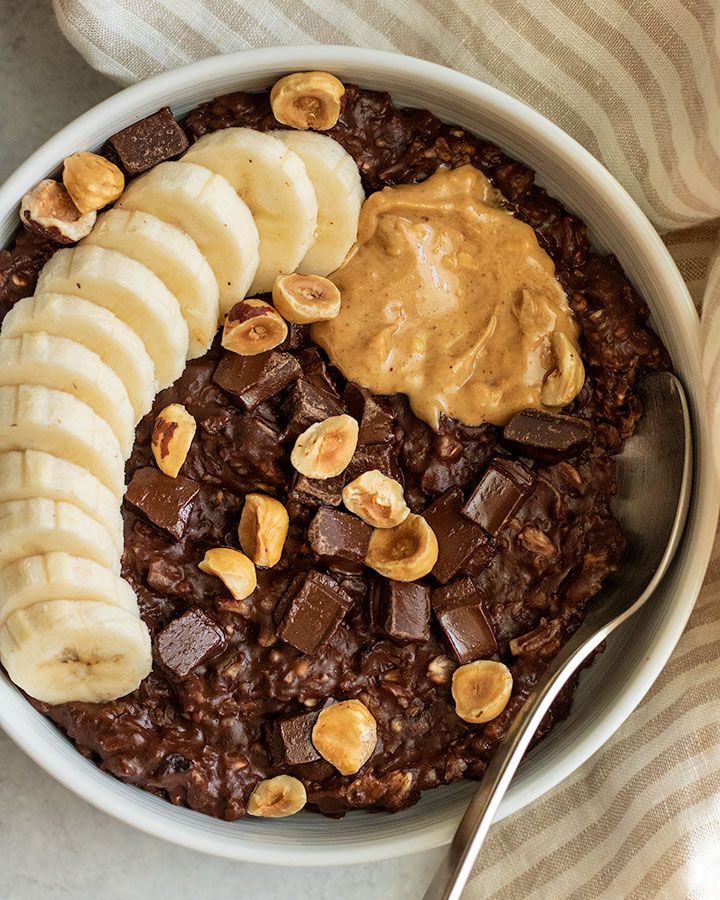 a bowl filled with oatmeal topped with bananas and chocolate