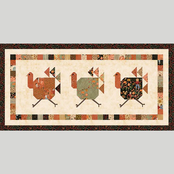 a quilted wall hanging with four roosters on it's sides and two flags in the middle